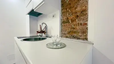 a kitchen counter with a sink and a glass at Domus Jana 30 in Rome