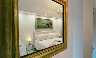a mirror on a wall with a bed in a room at Domus Jana 30 in Rome
