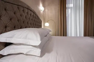 a bedroom with a large bed with white pillows at Roma suite hotel in Rome