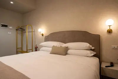 a bedroom with a bed with white pillows and two lights at Roma suite hotel in Rome