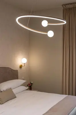 a bedroom with a large bed with a light fixture at Roma suite hotel in Rome
