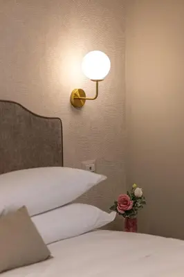 a bedroom with a bed with a lamp on the wall at Roma suite hotel in Rome