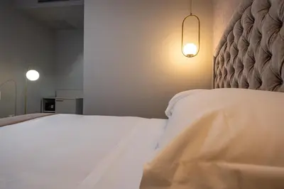 a bedroom with a white bed and two lights at Roma suite hotel in Rome