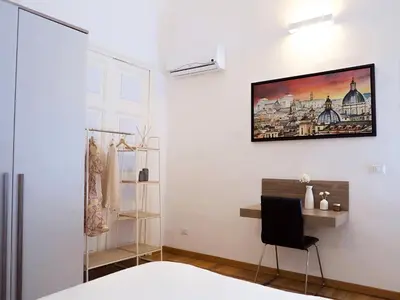 a room with a bed and a chair and a picture on the wall at Casa Bellezza a Cola di Rienzo in Centro in Rome