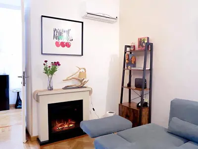 a living room with a fireplace and a blue couch at Casa Bellezza a Cola di Rienzo in Centro in Rome