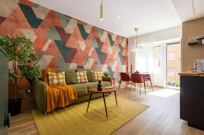 a living room with a couch and a colorful wall at Yasmine Luxury Apartment in San Giovanni in Rome