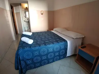 a bedroom with a bed with a blue comforter at Cressy in Rome