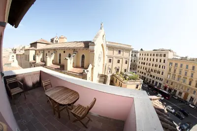 a balcony with two chairs and a table on a building at San Vito Cozy Apartment in Rome