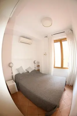 a bedroom with a bed in a round mirror at San Vito Cozy Apartment in Rome