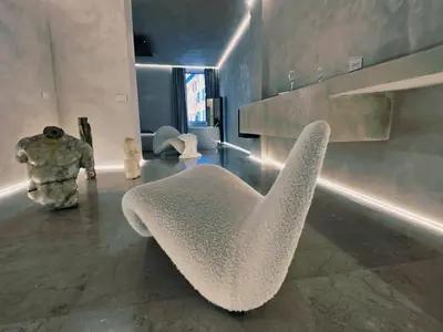 a living room with a white chair and sculptures at DUNE at Spanish Steps Luxury Apartment-Suite in Rome