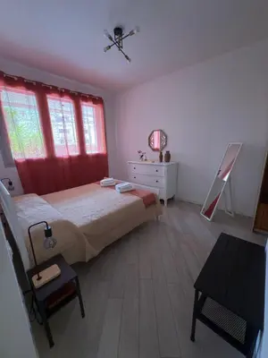 a bedroom with a bed with red curtains and a table at La Casa di Lella in Rome