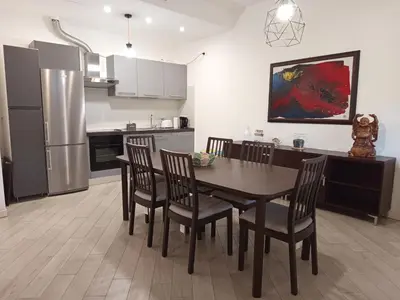 a kitchen with a table and chairs and a refrigerator at La Casa di Lella in Rome