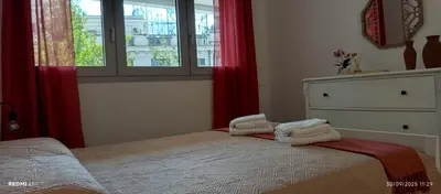 a bedroom with a bed with red curtains and a window at La Casa di Lella in Rome