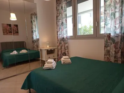 a room with two green beds and a mirror at La Casa di Lella in Rome