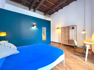 a blue bedroom with a bed and a desk at Casa Polveriera at Colosseum in Rome