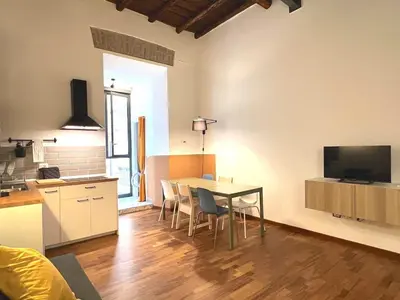 a kitchen and dining room with a table and chairs at Casa Polveriera at Colosseum in Rome