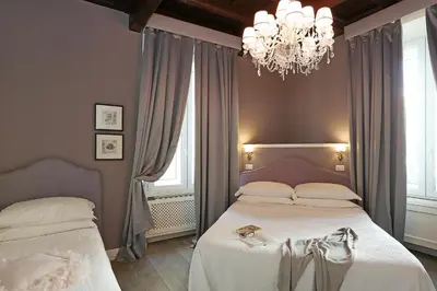 a bedroom with two beds and a chandelier at Piazzetta de' Monti Suites in Rome