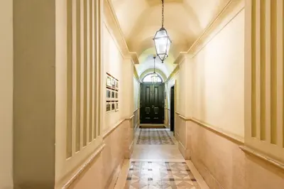 a hallway with a black door and a tile floor at Piazzetta de' Monti Suites in Rome