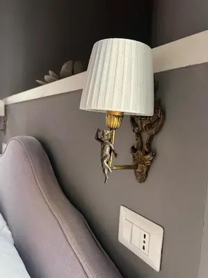 a lamp on a wall next to a bed at Piazzetta de' Monti Suites in Rome