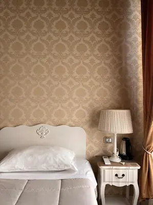 a bedroom with a bed and a table with a lamp at Piazzetta de' Monti Suites in Rome