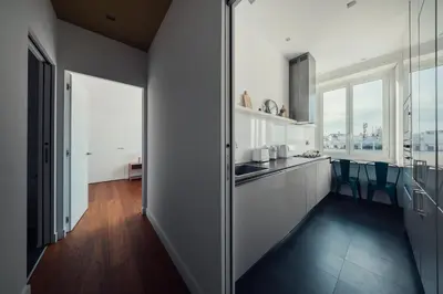 a kitchen with white cabinets and blue chairs at Fifi's Flaminio Panoramic Apartment 120mq in Rome