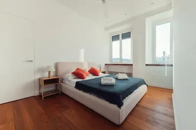 a white bedroom with a large bed with red pillows at Fifi's Flaminio Panoramic Apartment 120mq in Rome