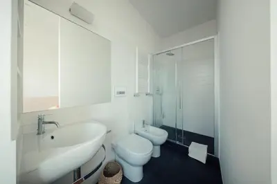 a white bathroom with a sink and a toilet at Fifi's Flaminio Panoramic Apartment 120mq in Rome