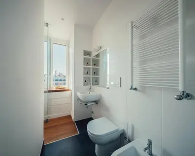 a white bathroom with a toilet and a sink at Fifi's Flaminio Panoramic Apartment 120mq in Rome