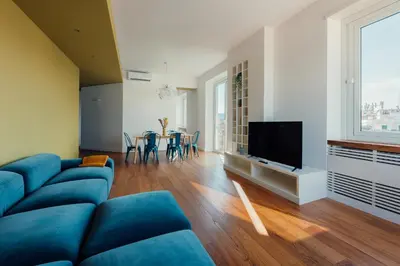 a living room with a blue couch and a television at Fifi's Flaminio Panoramic Apartment 120mq in Rome