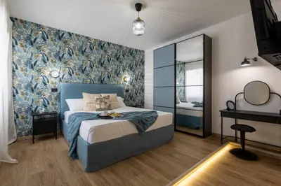 a bedroom with a bed with a blue headboard at Aida Luxury Apartment in San Giovanni in Rome