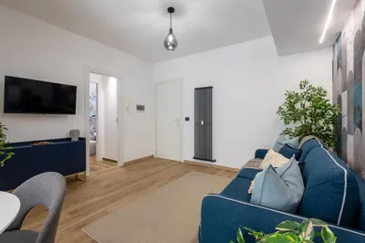 a living room with a blue couch and a tv at Aida Luxury Apartment in San Giovanni in Rome