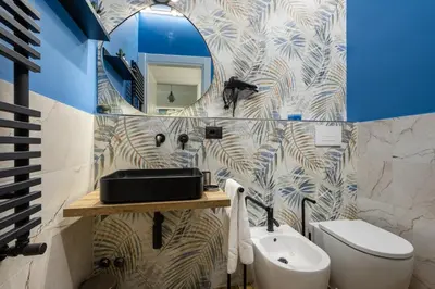 a bathroom with a sink and a toilet and a mirror at Aida Luxury Apartment in San Giovanni in Rome