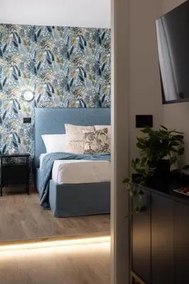 a bedroom with a bed with a blue and gold wallpaper at Aida Luxury Apartment in San Giovanni in Rome