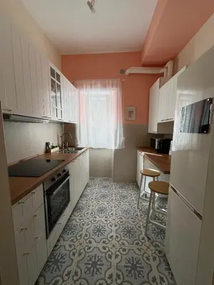 a kitchen with white cabinets and a tile floor at CasaCoco con posto auto e 2 bagni in Rome