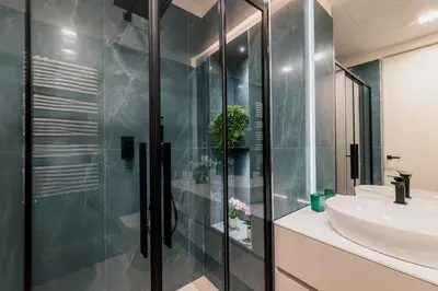a bathroom with a glass shower and a sink at Exclusive Domus Gaudia in Rome