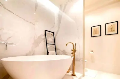 a bath tub in a bathroom with a marble wall at Appartamento Marissia in Rome