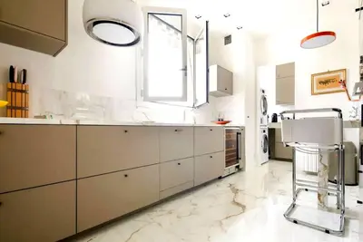 a kitchen with white cabinets and a window at Appartamento Marissia in Rome