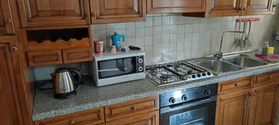a kitchen with a microwave and a stove top oven at Colosseum house jp in Rome