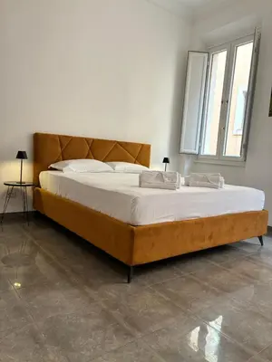 a bedroom with a large bed with white sheets at DolceVite - Fontana Di Trevi in Rome