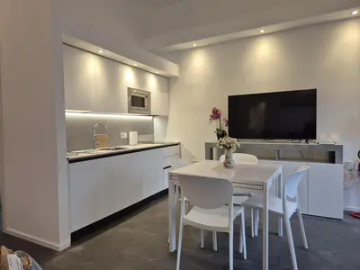 a kitchen with a white table and white chairs at Domus Tirso Mini Loft with independent entrance in Rome