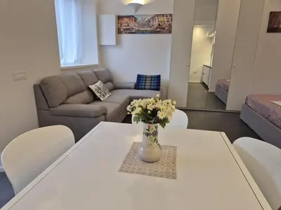 a living room with a table with a vase of flowers on it at Domus Tirso Mini Loft with independent entrance in Rome
