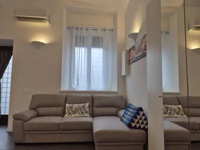 a living room with a couch and a window at Domus Tirso Mini Loft with independent entrance in Rome