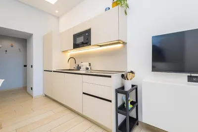 a kitchen with a sink and a flat screen tv at Colosseo Apartment holiday Venus Appartamento al Colosseo a Monti in Rome