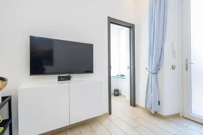 a living room with a flat screen tv on a white wall at Colosseo Apartment holiday Venus Appartamento al Colosseo a Monti in Rome