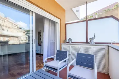 two chairs and a table in a room with windows at Vatican Hills Apartment in Rome