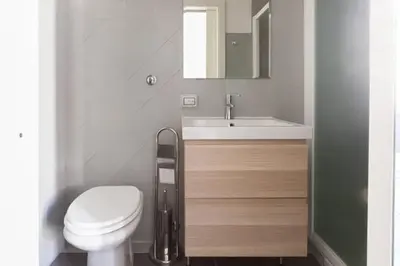 a bathroom with a toilet and a sink and a mirror at Domus Merulana Bed and Breakfast in Rome