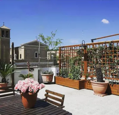 a balcony with potted plants and a wooden fence at Appartamento Delle Grazie in Rome