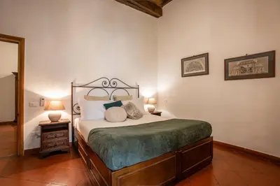 a bedroom with a bed and two lamps and a mirror at Santa Caterina by the Pantheon - 2BR in Rome