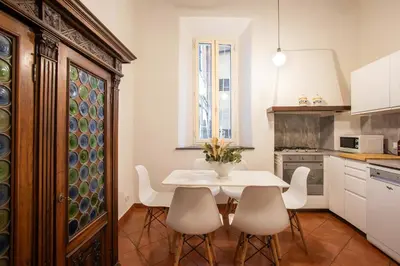 a kitchen with a white table and chairs at Santa Caterina by the Pantheon - 2BR in Rome