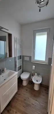 a bathroom with a sink and a toilet and a window at San Paolo Hideout in Rome